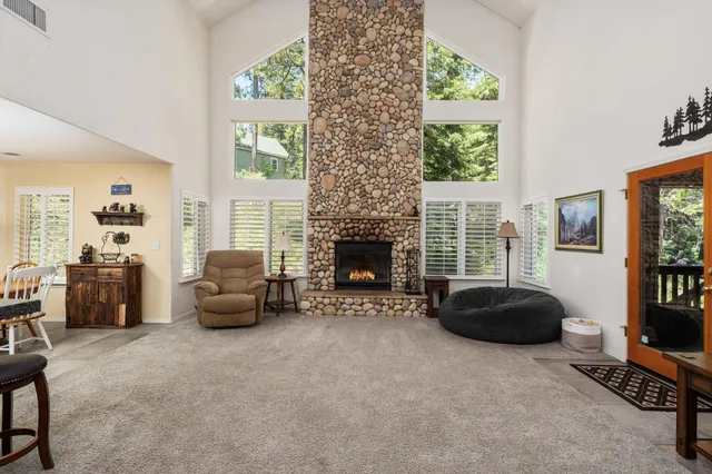 a living room with furniture a fireplace and a large window