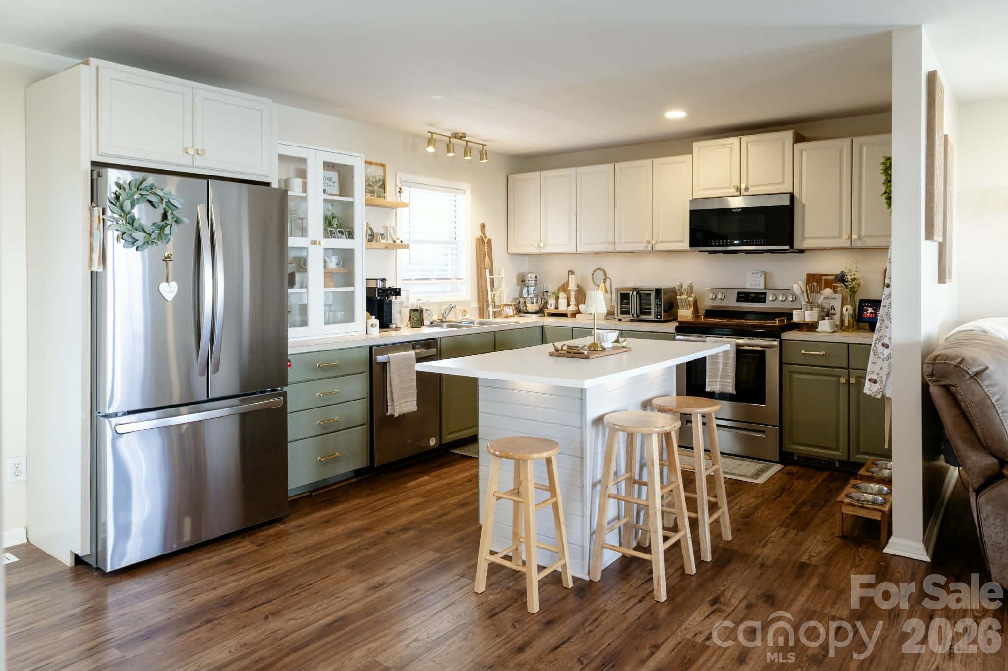 202 East Rice Street Landis, NC 28088 - Photo 8 of 23 a kitchen with stainless steel appliances granite countertop a refrigerator a stove a sink a dining table and chairs with wooden floor