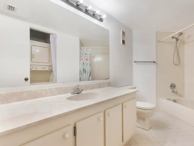 a bathroom with a sink a toilet and a large mirror