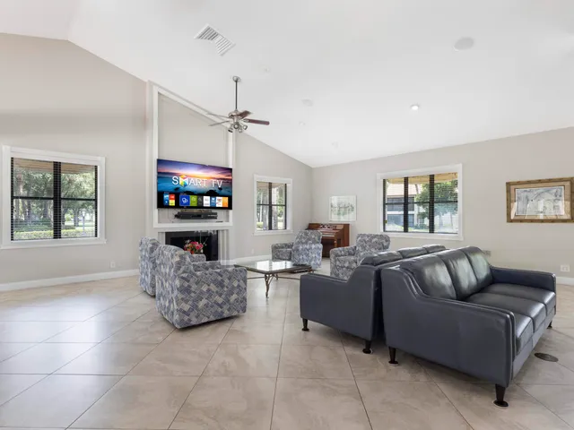 a living room with furniture a flat screen tv and a window