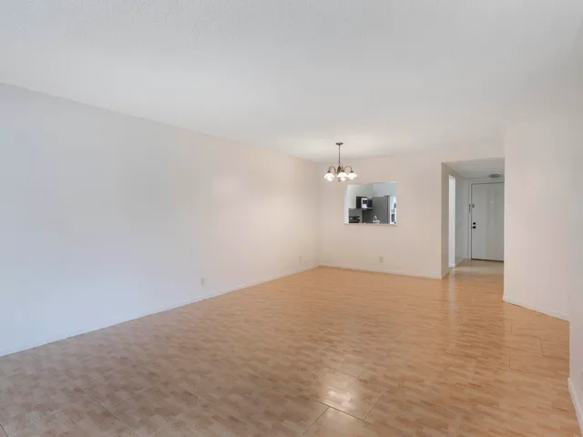 a view of empty room with wooden floor and windows