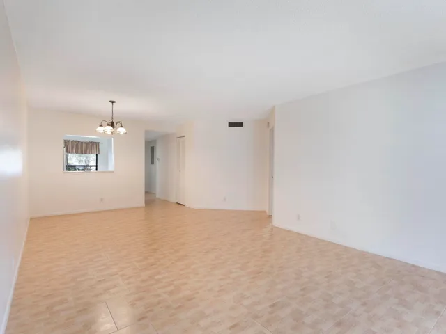 an empty room with windows and cabinet