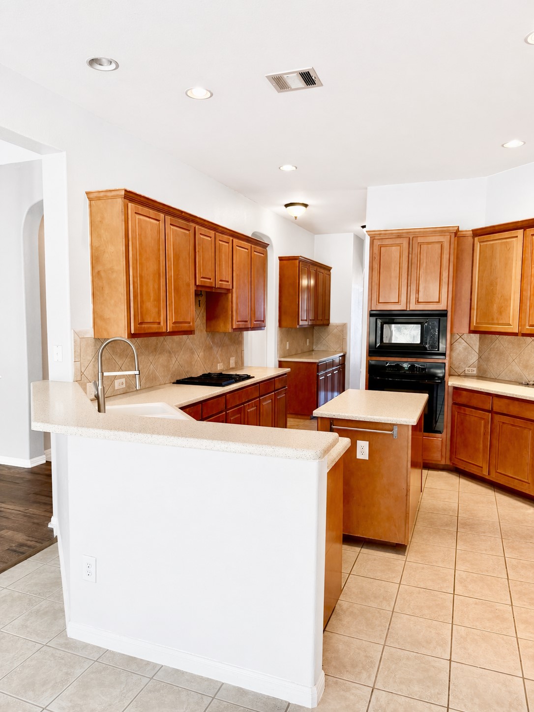 8024 Cobblestone Austin, TX 78735 - Photo 6 of 31 Spacious kitchen featuring light wood cabinetry, light countertops, and a central island