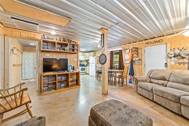 a dining room with stainless steel appliances a table and chairs
