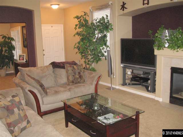 1310 Arbor Court Reno, NV 89521 - Photo 2 of 9 a living room with furniture a flat screen tv and a fireplace