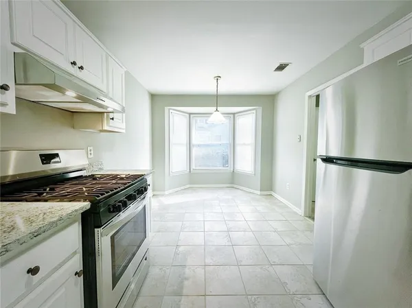 a kitchen with stainless steel appliances granite countertop a stove and a refrigerator