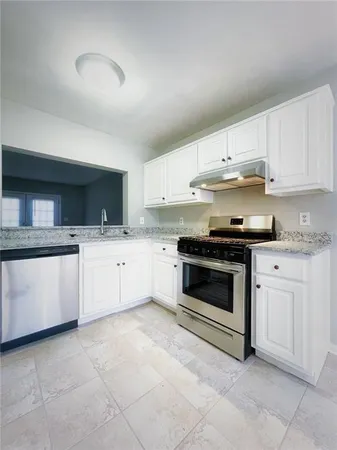 a kitchen with granite countertop white cabinets and white appliances