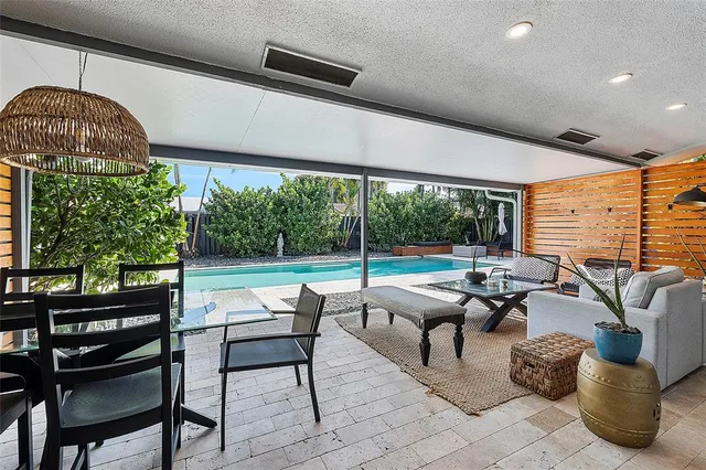 a living room with patio furniture and a floor to ceiling window