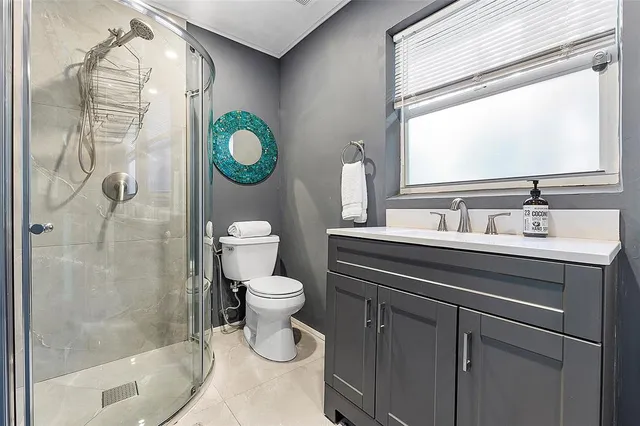 a bathroom with a sink a toilet and shower