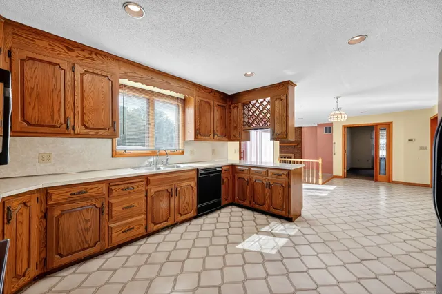 a large kitchen with a stove a sink dishwasher and a refrigerator