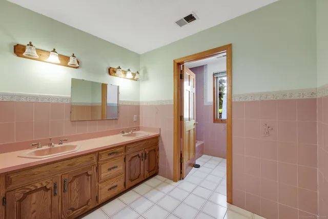 a spacious bathroom with a double vanity sink a mirror and a shower