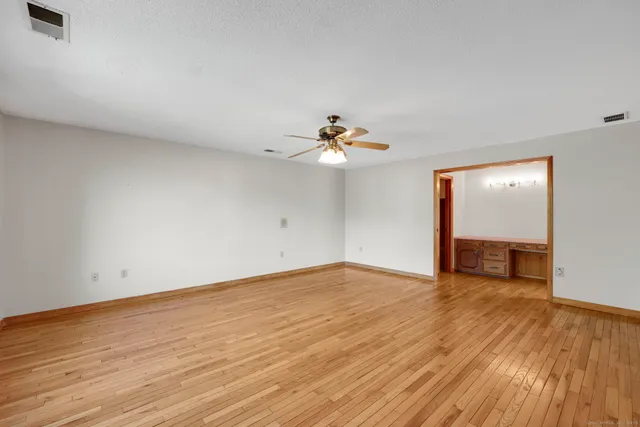 a view of an empty room with wooden floor