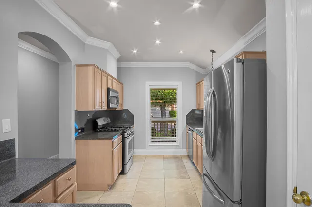 a kitchen with stainless steel appliances granite countertop a refrigerator and a sink