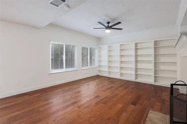 a view of empty room with wooden floor and fireplace