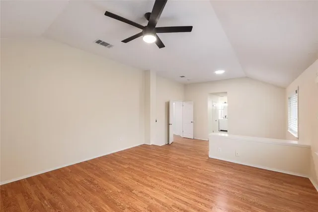 an empty room with a ceiling fan and window