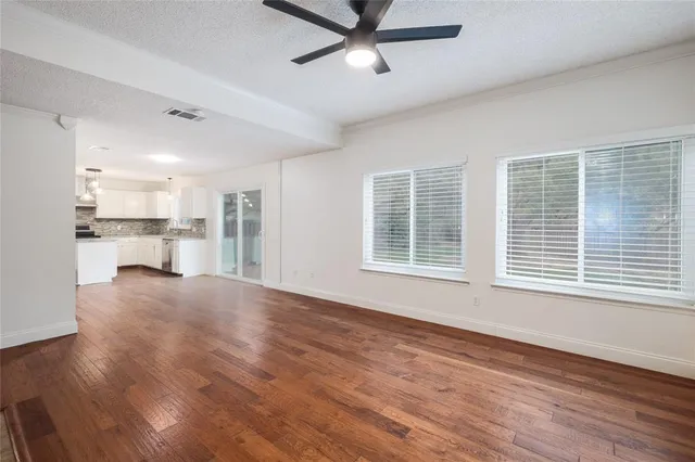 a view of a kitchen with a fridge wooden floor and a window