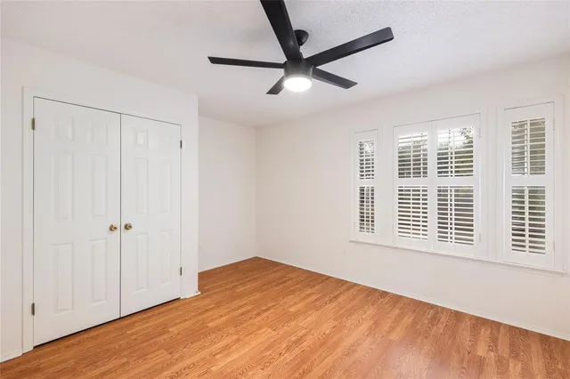 a view of a big room with wooden floor and windows