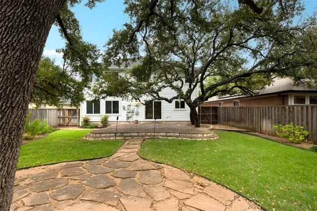 a view of a house with a yard and wooden fence