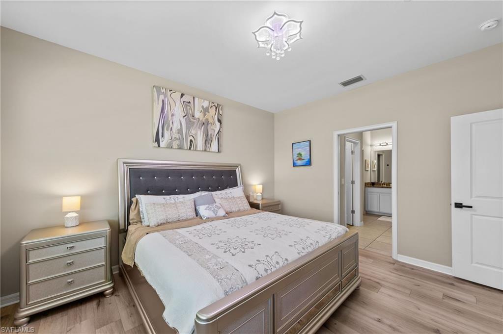 9366 Pocida Court, Unit 202 Naples, FL 34119 - Photo 17 of 44 a bedroom with a bed and a lamp on dresser