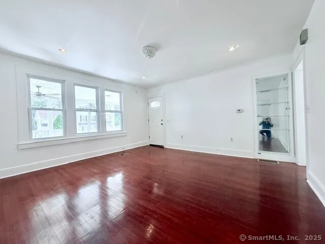 an empty room with wooden floor and windows