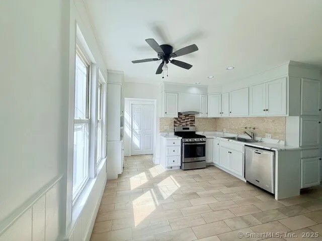a kitchen with stainless steel appliances granite countertop a stove and a refrigerator