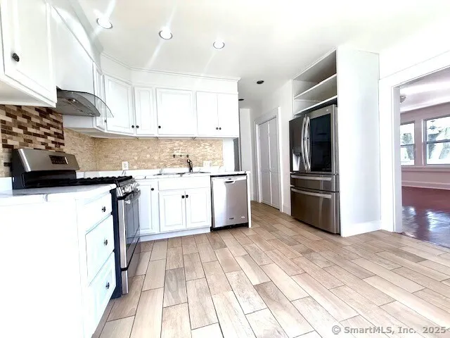 a kitchen with a sink a counter top space cabinets and stainless steel appliances