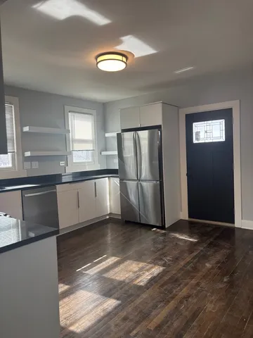 a view of a kitchen with wooden floor and electronic appliances