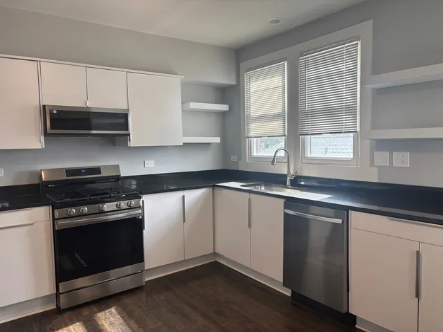 a kitchen with stainless steel appliances a sink a stove and cabinets