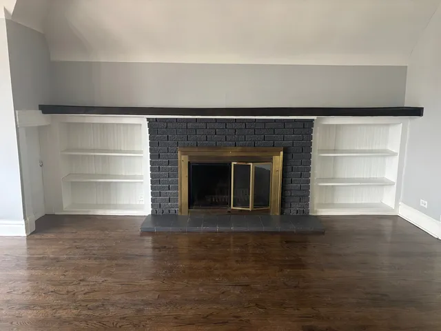 a living room with a fireplace and a hard wood floor