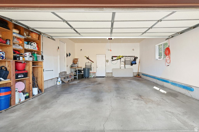 865 South 325 West Orem, UT 84058 - Photo 30 of 38 Spacious garage with concrete flooring, built-in wooden shelving, and a large window