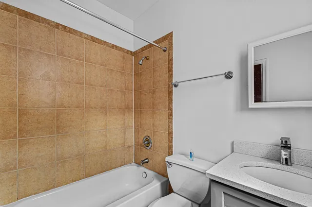 a bathroom with a sink mirror vanity and toilet