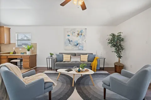 a bedroom with a bed a couch and potted plant on the dresser