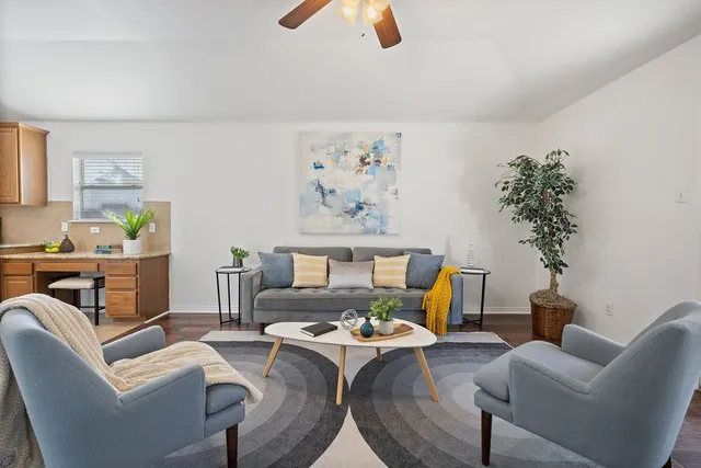 a bedroom with a bed a couch and potted plant on the dresser