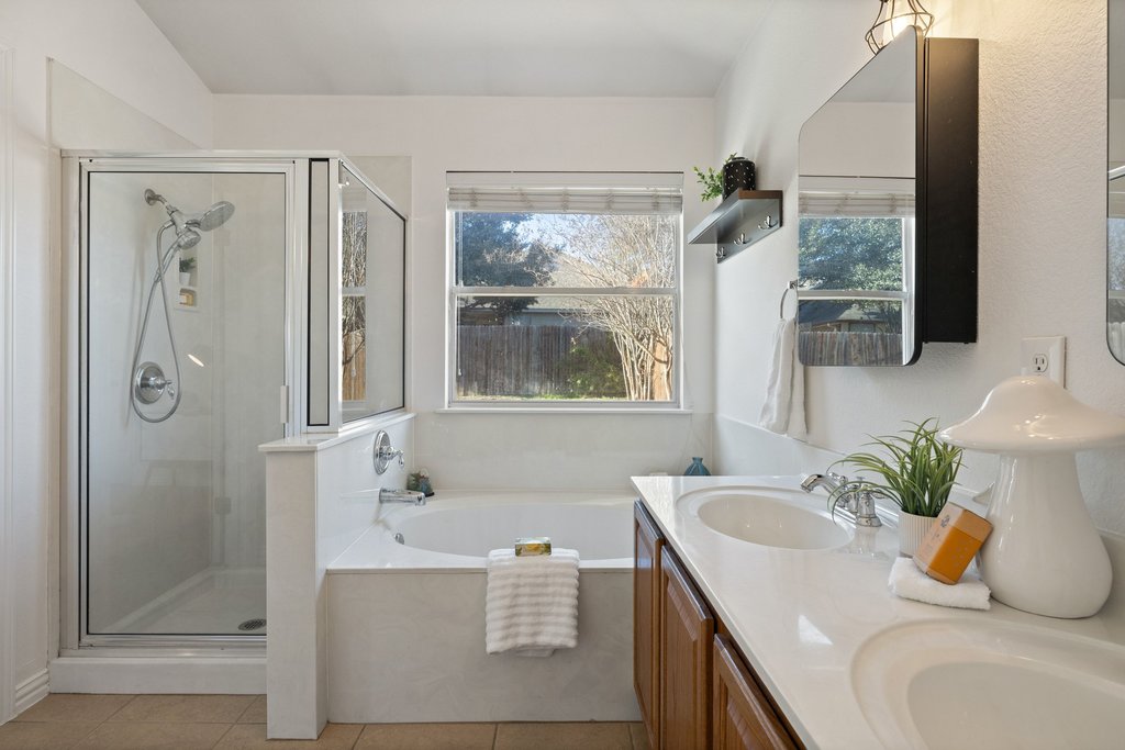 218 Calline Mayes Run Buda, TX 78610 - Photo 17 of 27 a bathroom with a granite countertop sink and a window