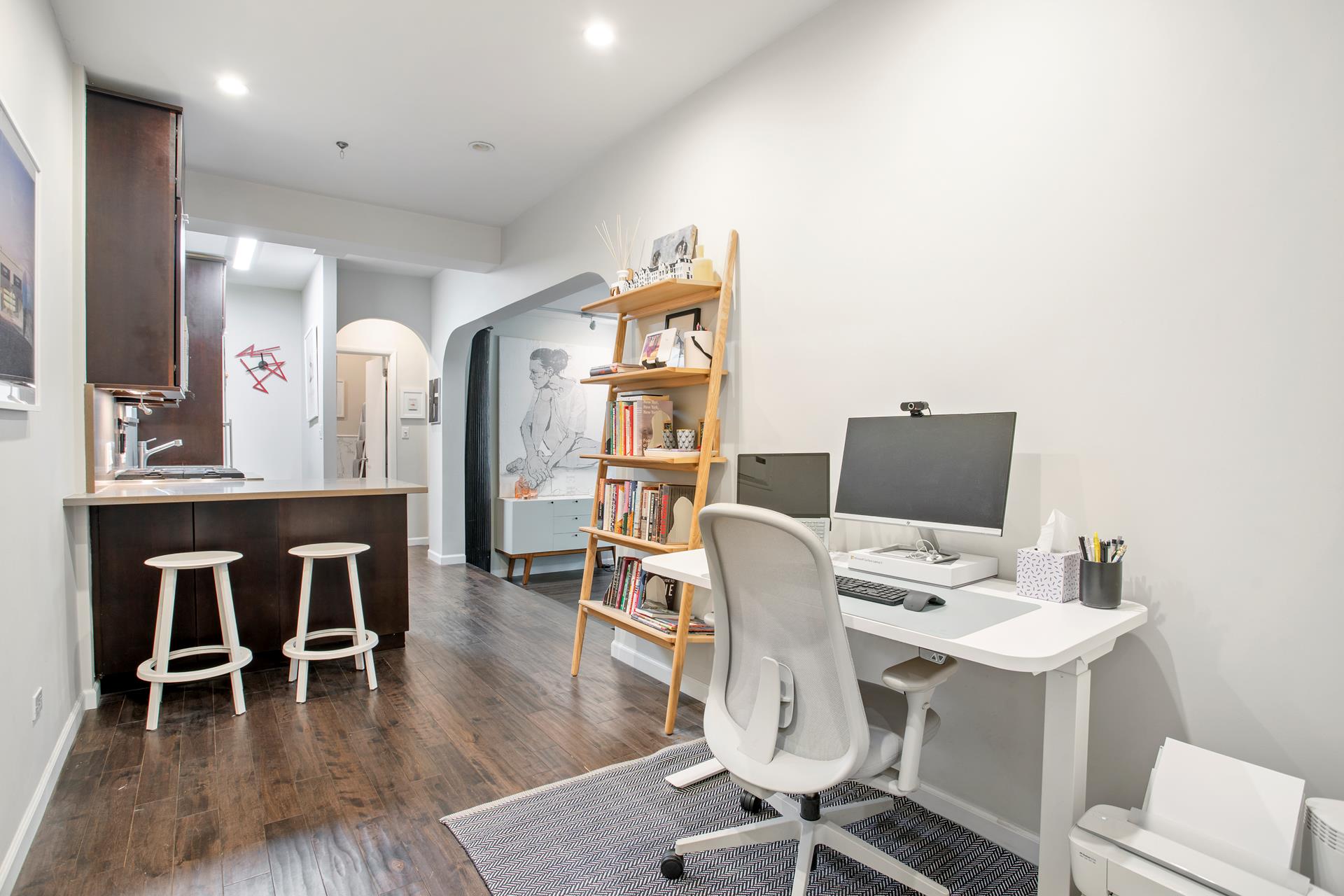 a view of a workspace with furniture and wooden floor