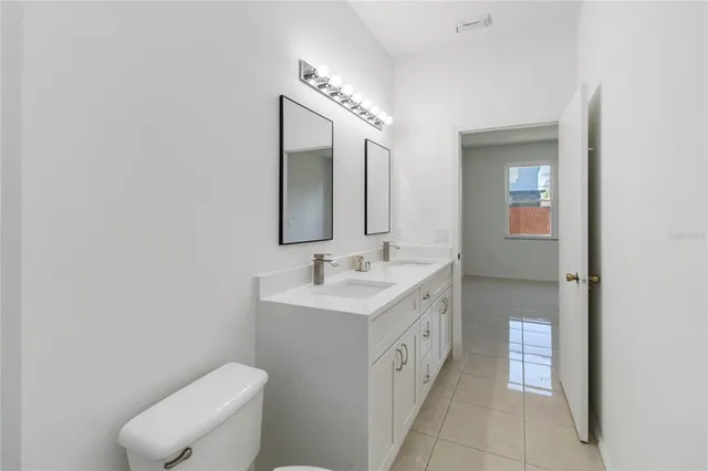 a spacious bathroom with a toilet sink and mirror