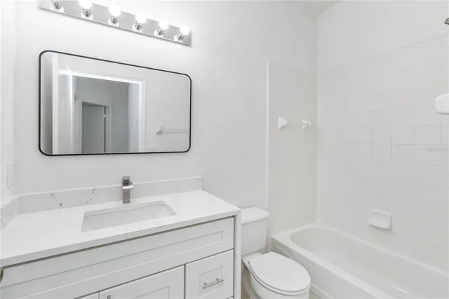 a bathroom with a toilet a sink a vanity and mirror