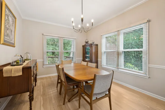 a view of a dining room with furniture a chandelier and wooden floor