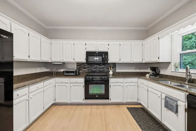 a kitchen with granite countertop white cabinets and white appliances