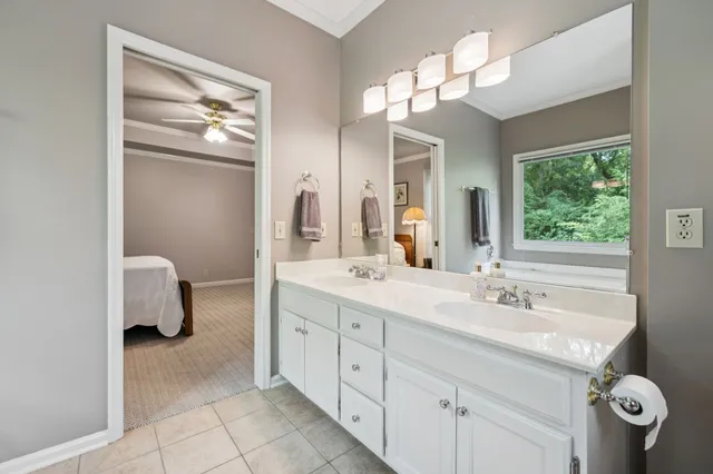 a spacious en suite bathroom with a double vanity sink a mirror a and a shower
