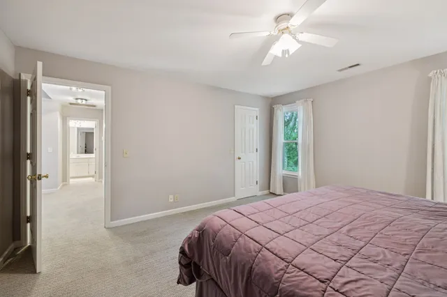 an empty room with windows and ceiling fan