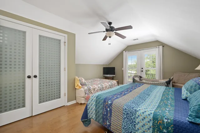 a bedroom with a bed a window and a chandelier
