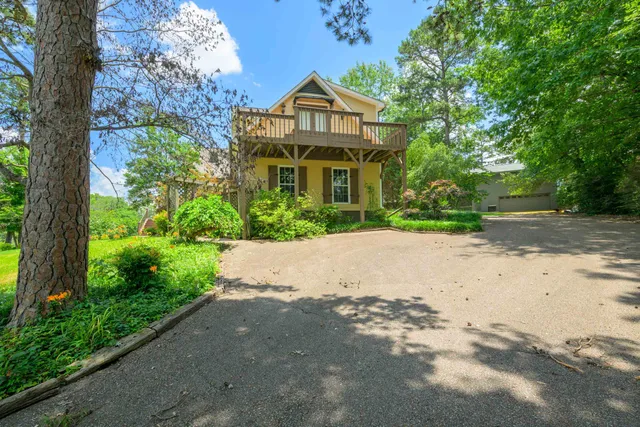 a front view of a house with a yard and trees
