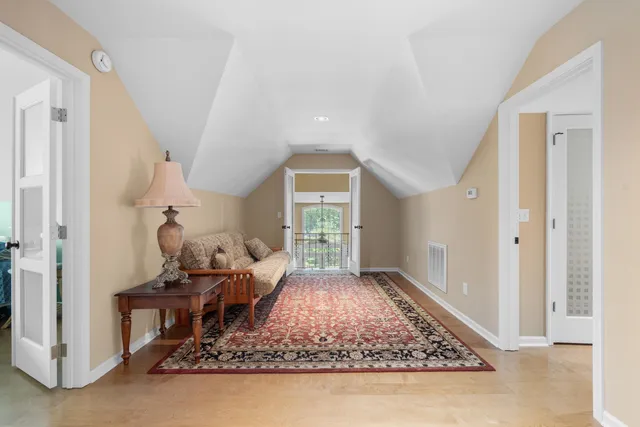 a view of a patio with couches potted plants and a wooden floor