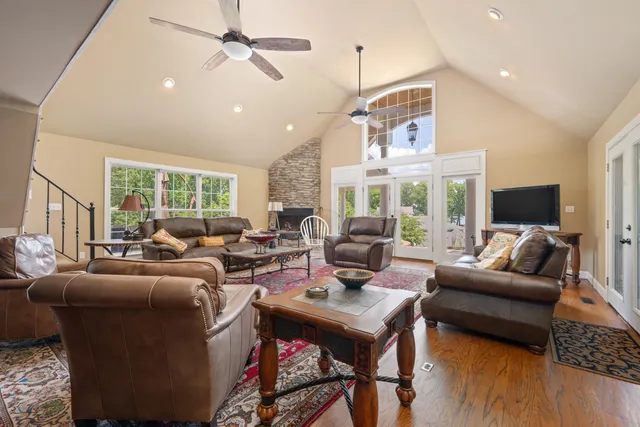 a living room with furniture fireplace and a large window