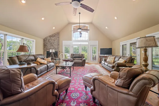 a living room with furniture fireplace and large windows