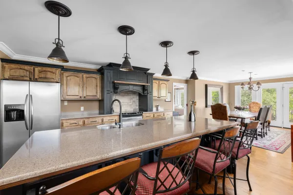 a kitchen with a dining table chairs and chandelier