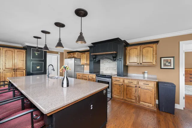 a kitchen with stainless steel appliances granite countertop sink stove and wooden floor