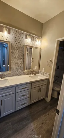 a bathroom with double vanity and a large mirror