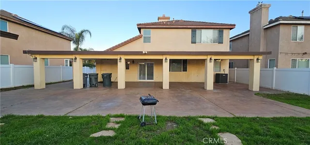 a view of a white house next to a yard and a large tree